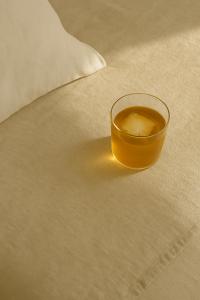 a glass of liquid sitting on top of a bed at Casa da Praia in Paredes da Vitória