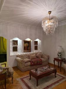 a living room with a couch and a chandelier at Comfyheliopolis in Cairo