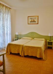 a bedroom with a bed with a green headboard at Residence Eucalipti in Alghero