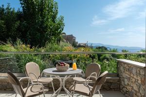 a patio with a table and chairs on a balcony at Kassandra Bay Resort, Suites & Spa in Vassilias