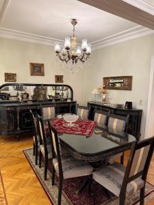 a dining room with a table and chairs and a chandelier at Comfyheliopolis in Cairo