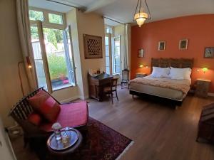 a bedroom with a bed and a desk in a room at La Résidence des Indes in La Rochelle