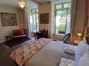 a bedroom with a large bed in a room with windows at La Résidence des Indes in La Rochelle +19 photos