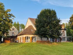 ein großes Haus mit einem Baum im Hof in der Unterkunft auberge de jeunesse Troyes rosières in Rosières-près-Troyes