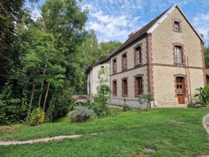 ein altes Backsteinhaus mit einem Rasenhof in der Unterkunft auberge de jeunesse Troyes rosières in Rosières-près-Troyes