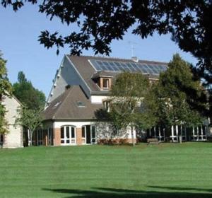 ein großes Haus mit Sonnenkollektoren auf dem Dach in der Unterkunft auberge de jeunesse Troyes rosières in Rosières-près-Troyes