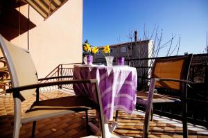 einen Tisch mit einem lila Tischtuch auf dem Balkon in der Unterkunft Apartments Ida Cres in Cres