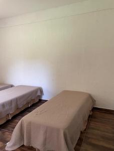 twee bedden in een kamer met een muur bij Suíte rural in Foz do Iguaçu