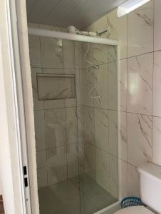 een douche met een glazen deur in een badkamer bij Suíte rural in Foz do Iguaçu