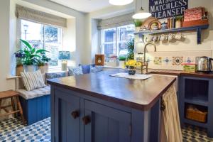 une cuisine avec un îlot bleu et un comptoir dans l'établissement Pantile Cottage, à Pickering 13 autres photos