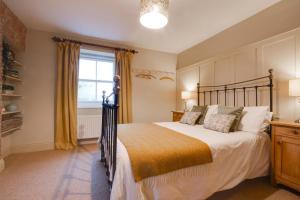 une chambre avec un grand lit et une fenêtre dans l'établissement Pantile Cottage, à Pickering