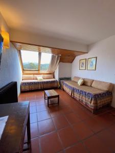 a living room with two beds and a large window at DUT Bariloche con Maxisol in San Carlos de Bariloche
