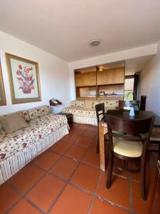 a room with two beds and a table and chairs at DUT Bariloche con Maxisol in San Carlos de Bariloche