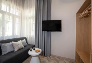 a living room with a couch and a tv at Alba Boutique Hotel in Chania Town