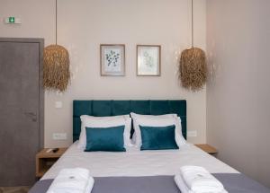 a bedroom with a bed with blue and white pillows at Alba Boutique Hotel in Chania Town