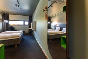 a hotel room with two beds and a mirror at Comfort Hotel RunWay in Gardermoen +22 photos