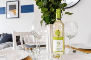 a bottle of wine sitting on a table with two glasses at Stylish 2BR Apartment near Sheffield City Centre in Sheffield