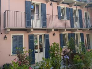 a building with blue shutters and a balcony at La Corte dei Mercanti by Stresahome - Centro Storico in Stresa