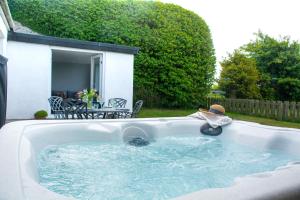 a child is sitting in a swimming pool at Gamekeepers Cottage in Holyhead
