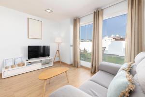 a living room with a couch and a tv at Travel Habitat - Ático Centro in Valencia