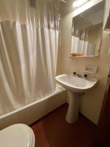 a bathroom with a sink and a shower curtain at DUT Bariloche con Maxisol in San Carlos de Bariloche