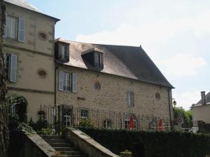 a large stone building with a black roof at La Maison du Cèdre in Bénévent-lʼAbbaye