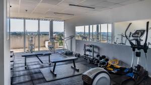 a gym with treadmills and cardio equipment and windows at Penthouse ROBELINI - Terraza, jacuzzi & vistas in Asuncion