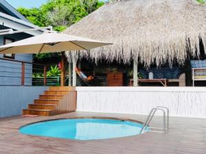 a swimming pool with an umbrella and a house at Santa Vista 1 in Santa Maria