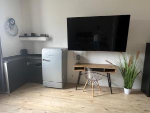 a room with a refrigerator and a desk and a tv at Best-Budged24 in Offenburg