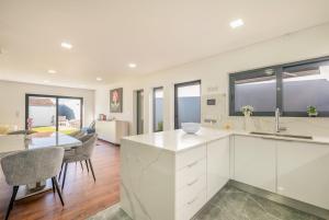 a kitchen with white cabinets and a dining room at GuestReady - Villa Belas in Sintra
