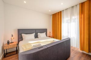 a bedroom with a large bed and a large window at GuestReady - Villa Belas in Sintra