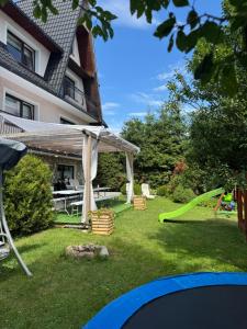 Zubrzyca GórnaにあるWolna chataのテーブルと緑の滑り台のある裏庭