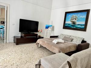 a living room with a couch and a flat screen tv at DIMORA ELIVA in Monopoli