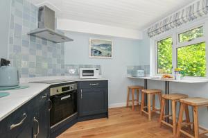 een keuken met zwarte kasten en een aanrecht bij 2 Porthilly Cottages in Wadebridge +18 foto's