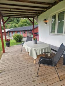 a patio with a table and chairs on a deck at Villa Svale, privat og fredelig in Kristiansand