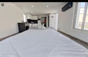 a large white bed in a room with a window at Maison individuelle Aytré plage terrain clos 280m2 très calme in Aytré