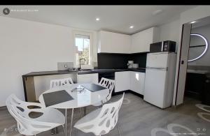 a kitchen with a table and chairs and a refrigerator at Maison individuelle Aytré plage terrain clos 280m2 très calme in Aytré