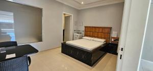 a small room with a bed and a table and a desk at Pousada Ponta Negra in Manaus