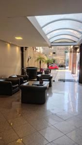 a lobby with couches and tables in a building at Extração de Hotel com ótimo custo benefício in Curitiba