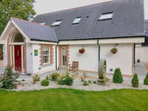 una casa blanca con una puerta roja y un patio en Delphi Lodge, en Donaghmore
