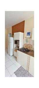 a kitchen with white cabinets and a white refrigerator at Apartamento - Centro Itapuã - 2Q in Vila Velha