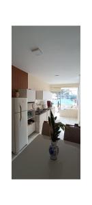 a kitchen with a refrigerator and a vase with a plant at Apartamento - Centro Itapuã - 2Q in Vila Velha +5 photos