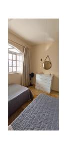 a bedroom with a bed and a dresser and a mirror at Apartamento - Centro Itapuã - 2Q in Vila Velha