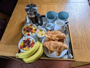 a tray of breakfast foods on a wooden table at The Manse featuring the Daisy Camrose in Haverfordwest