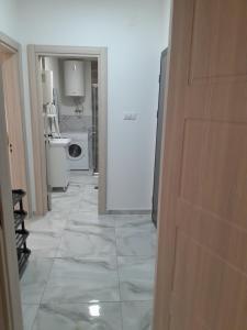 a hallway leading to a kitchen with a washing machine at Mara in Prokuplje