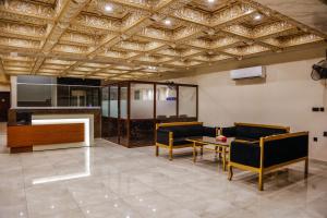 a living room with couches and a table and a television at Lataska Hotel in Bahawalpur