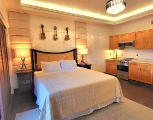 1 dormitorio con 1 cama con guitarras en la pared en Polynesian Koi Pond Gardens Condo in Hilo w pool, en Hilo
