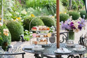 a table with a tray of pastries and desserts on it at Summer Lodge Country House Hotel in Evershot
