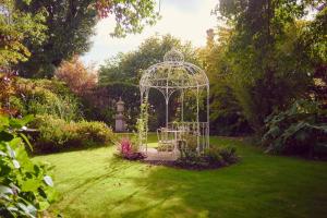 a garden with a gazebo in the grass at Summer Lodge Country House Hotel in Evershot