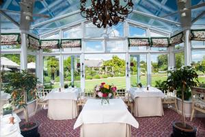a dining room with tables and chairs and a chandelier at Summer Lodge Country House Hotel in Evershot